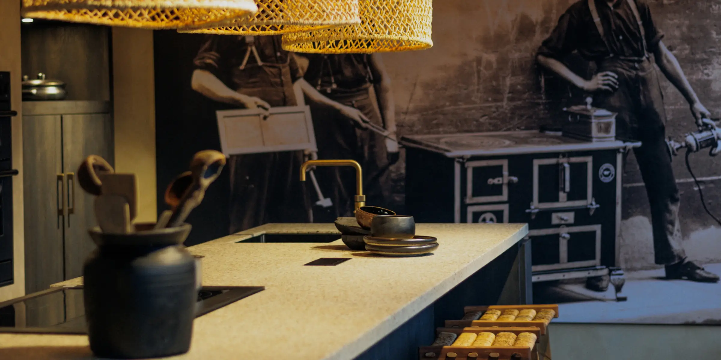 Industrielle Küche mit Betonarbeitsplatte, Messingarmatur und warmer Beleuchtung – Beispiel dafür, wie Duftmarketing die Raumstimmung verstärkt.